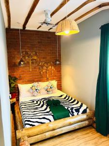 Bett in einem Zimmer mit Ziegelwand in der Unterkunft Swahili Villa in Arusha