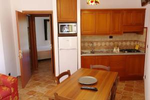 a kitchen with a wooden table and a kitchen with a sink at Bari Sardo Le More Suite 3 in Bari Sardo