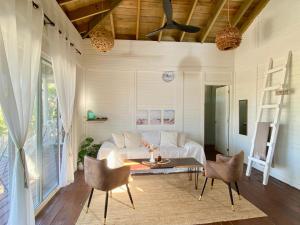a living room with a bed and a table and chairs at HOLBOX PUERTA DEL MAR in Holbox Island +62 photos