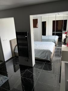 Schlafzimmer mit einem Bett und einem Spiegel in der Unterkunft Villa near CDG Paris aeroport in Arnouville-lès-Gonesse