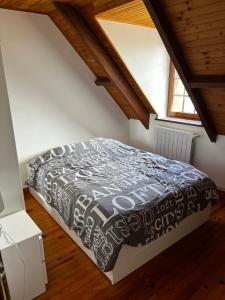 Schlafzimmer mit einem Bett mit einer schwarzen und weißen Bettdecke in der Unterkunft Villa near CDG Paris aeroport in Arnouville-lès-Gonesse