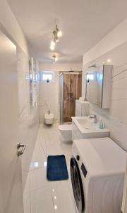 y baño blanco con lavadora. en Novi Apartman NPS Pula, en Pula