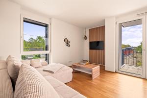 een witte woonkamer met een bank en een tafel bij SEEzauber in dirketer Seenähe in Friedrichshafen