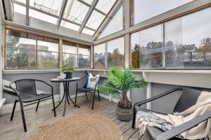 a conservatory with chairs and a table in a room with windows at Apartment in Tromsø city center in Tromsø