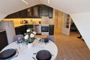 a kitchen with a white table with chairs and a kitchen with a tableablish at Apartment in Tromsø city center in Tromsø