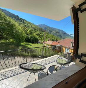 ein Balkon mit zwei Stühlen und einem Tisch mit Aussicht in der Unterkunft Mountain Serenity in Konitsa