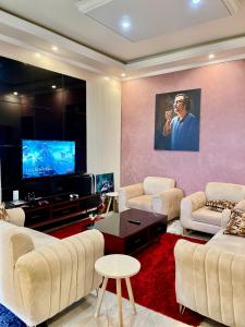 een woonkamer met witte meubels en een flatscreen-tv bij Sweet home apartment in Namulanda