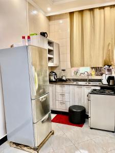 een keuken met een roestvrijstalen koelkast en een wastafel bij Sweet home apartment in Namulanda