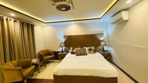 a hotel room with a bed and two chairs at Amyl's Garden in Islamabad +24 photos