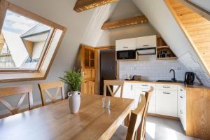 eine Küche und ein Esszimmer mit einem Holztisch in der Unterkunft U Dzikosa in Ząb