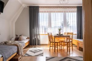 1 dormitorio con 1 cama, mesa y sillas en U Dzikosa en Ząb