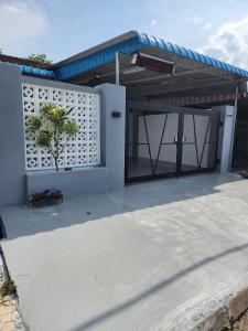 a house with a garage door with a palm tree at Sun Shine Home by Ipoh Maju Stay in Ipoh