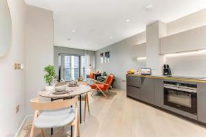 a kitchen and living room with a table and chairs at The Shypen - 2 bed in London