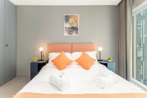 a bedroom with a large white bed with orange pillows at The Shypen - 2 bed in London