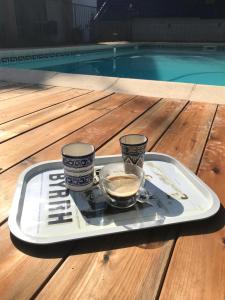 een dienblad met twee kopjes en een kom koffie op een tafel bij Le mas petit in Thuir