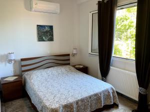 a bedroom with a bed and a window at Nick's Apartments Evia in Achladi