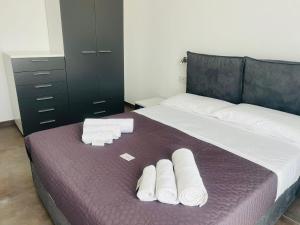 ein Schlafzimmer mit einem Bett mit gerollten Handtüchern darauf in der Unterkunft S'Aneddu e Oro in Alghero