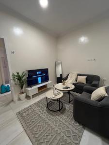 a living room with a couch and a tv at استديو مدخل خاص وجلسات خارجية in Riyadh