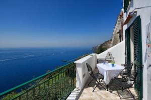 ein Balkon mit Tisch und Stühlen und dem Meer in der Unterkunft Casa Marianna in Conca dei Marini