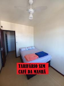 Una habitación con una cama con un cartel. en Recanto Boa Vista, en Joinville