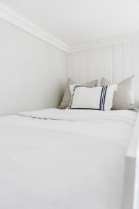 a white bedroom with a bed with white sheets and pillows at Studio apartment in central Oslo in Oslo