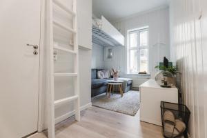 a white living room with a couch and a table at Studio apartment in central Oslo in Oslo