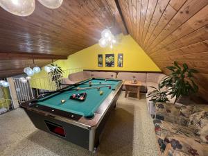 a billiard room with a pool table and a couch at Penzion na Lůkách in Horní Bečva