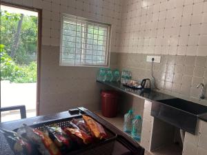 a kitchen with a counter with soda bottles on it at Rt Service Apartments Hotel in Velankanni