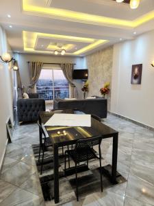 杜阿拉Magnifique appartement haut standing à Kotto, calme, propre, securise avec groupe electrogene et wifi的带桌子和沙发的客厅