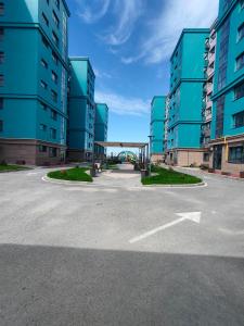 an empty parking lot in front of tall buildings at ЖК Prime Park in Shymkent