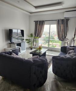 杜阿拉Magnifique appartement haut standing à Kotto, calme, propre, securise avec groupe electrogene et wifi的有两张沙发和一张桌子的客厅