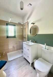 uma casa de banho com um WC branco e um lavatório. em LES CISTES em Mallemort