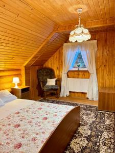 1 dormitorio con 1 cama, 1 silla y 1 ventana en Cottage Kalinka en Bukovel