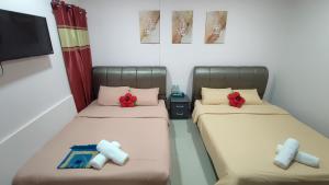2 Betten in einem Zimmer mit roten Bögen in der Unterkunft Santai Desa Chalet musleem 0nly in Brinchang