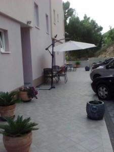 a patio with a table and an umbrella and chairs at SARITA Apartments 1 in Makarska