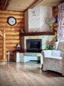 布克維的住宿－Cottage Kalinka，客厅配有沙发和墙上的时钟