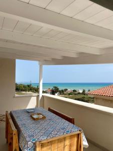 - une table sur un balcon avec vue sur l'océan dans l'établissement La Terrazza di Nonna Maria, à Realmonte