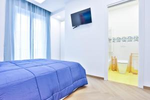 - une chambre avec un lit bleu et une télévision à écran plat dans l'établissement Casa NordOvest Cheerful Apartment, à Salerne