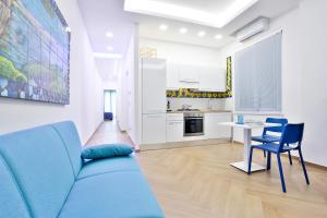 - un salon avec un canapé bleu et une table dans l'établissement Casa NordOvest Cheerful Apartment, à Salerne