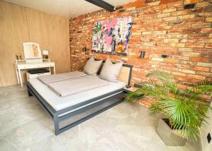 a bed in a room with a brick wall at DESIGN LOFT Herford - Parkplatz, WLAN, Netflix, PS4, Heimkino in Herford
