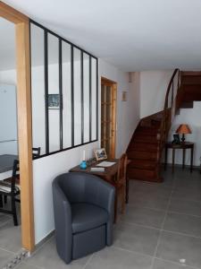 salon z krzesłem, stołem i schodami w obiekcie Chez Julou et Rosalie à Puilaurens w mieście Puilaurens