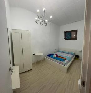 ein kleines Schlafzimmer mit einem Bett und einem Kronleuchter in der Unterkunft SAN Rafael in Barcelona