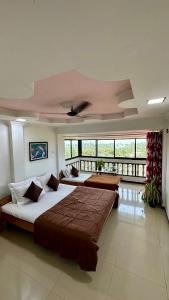 a large bedroom with two beds and a balcony at Sea Esta Resort & Cafe in Kashid