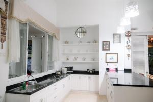 a white kitchen with a sink and a mirror at Kirana Guest House Bogor in Bogor
