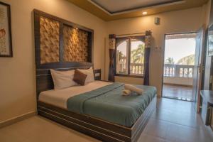 a bedroom with a large bed and a balcony at Sea Esta Resort & Cafe in Kashid