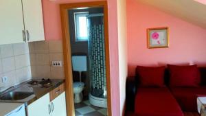a living room with a red couch in a kitchen at SARITA Apartments 1 in Makarska +81 photos