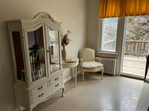 a room with a dresser and a chair and a mirror at m i g l i o r e in Pargas