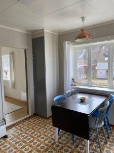 a dining room with a table and chairs and a window at Unstad Surfpacker in Unstad