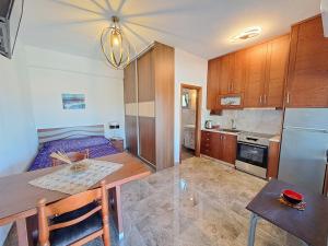 a kitchen and living room with a table and a couch at Nick's Apartments Evia in Achladi