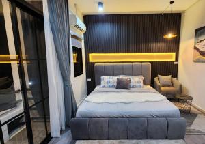 een slaapkamer met een groot bed en een stoel bij LS 2 Lasalle House,bts,Suvarnabhumi ,mega bangna in Ban Khlong Samrong